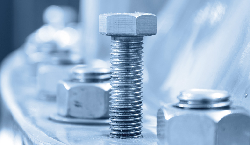 This image shows a close-up of metallic bolts and nuts on a machine part, illuminated by blue-tinted lighting, highlighting the texture and threading details.